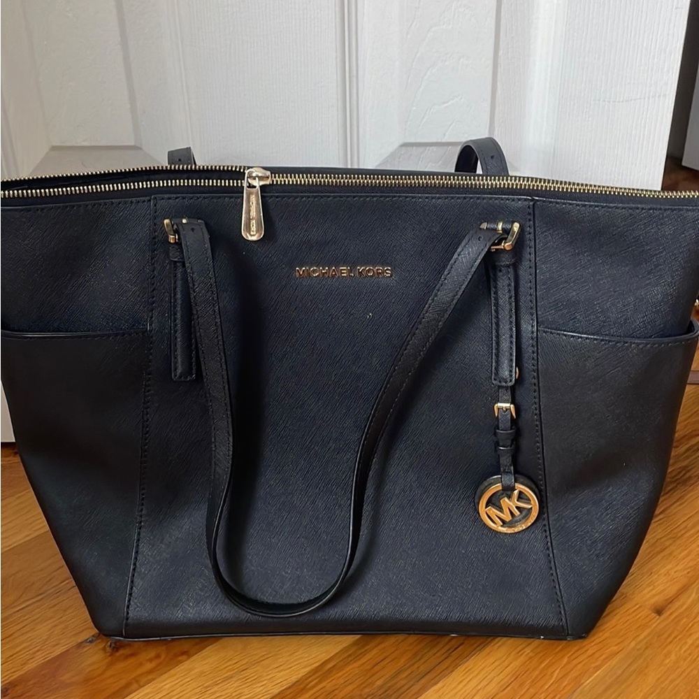 All black Michael Kors shoulder bag with 4 inside pockets and gold hardware.